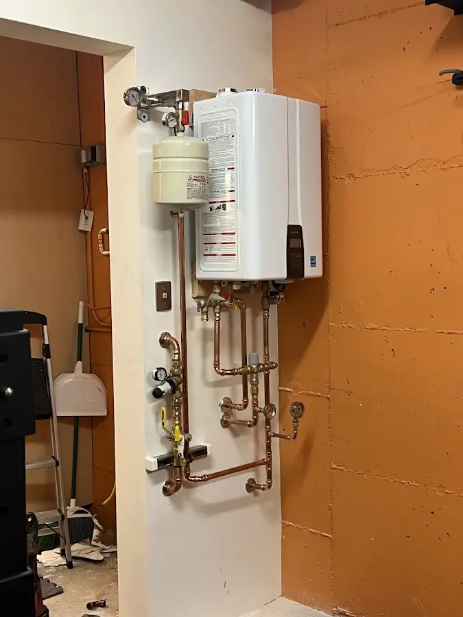 Plumbing technician inspecting water heater connections in Rockville Centre